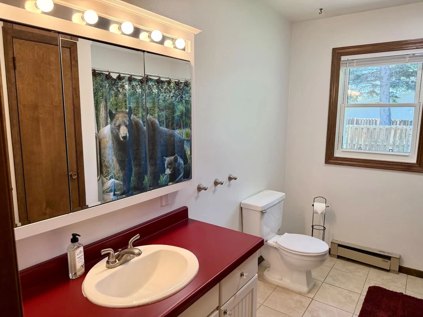 Upstairs bathroom with a wooden vanity, red countertop, and a curtained tub and shower